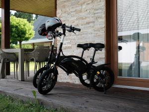 een motorfiets geparkeerd op een veranda naast een gebouw bij Apartment BRIN in Topolšica