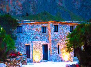 un edificio de piedra con luces delante en Gelsomino Sea View Suite & Spa en San Vito lo Capo