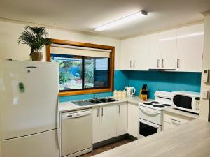 a kitchen with a white refrigerator and a sink at Da Ja Surf - Pet Friendly in Robe