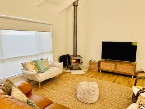 a living room with a flat screen tv and a couch at Bluebird Days - Pet Friendly in Robe