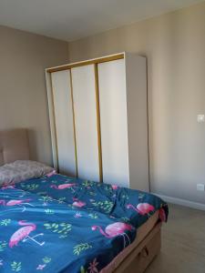 ein Schlafzimmer mit einem Bett mit rosa Flamingos darauf in der Unterkunft Złoty apartament Bokserska in Warschau