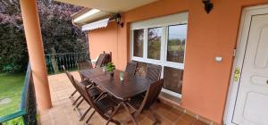 patio con mesa y sillas en el balcón en Dalias - Con Piscina, Jacuzzi, Parque Infantil, Juegos, 6 hab, 3 baños, en Argüero