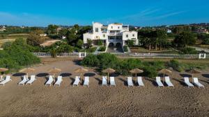 a group of chairs and umbrellas on a beach at Grand Bleu Anastazia in Porto Heli