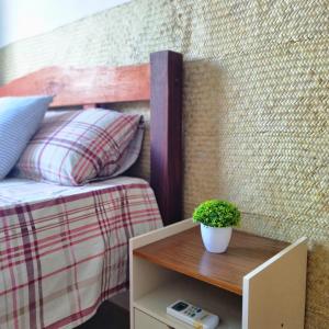 a table with a potted plant on top of a bed at Casa Areal Boipeba in Ilha de Boipeba