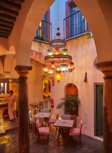 a restaurant with tables and chairs and a chandelier at La Sacristía in Tarifa