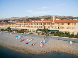 Family Hotel Pagus - All Inclusive في باغ: اطلالة جوية على فندق فيه ناس على الشاطئ