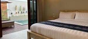 1 dormitorio con 1 cama y balcón con piscina en Pandan Villas, en Selong Belanak