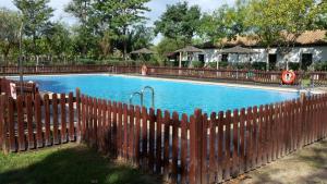a wooden fence in front of a swimming pool at Kampaoh El Rocío in El Rocío