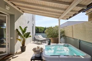 a hot tub sitting on a patio with a roof at Golden Apartments in Marina di Cecina