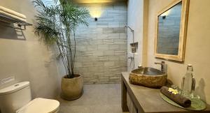 uma casa de banho com um lavatório, um WC e um chuveiro em Pandan Villas em Selong Blanak