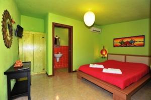 a green bedroom with a red bed and a bathroom at Butterfly House Bed & Breakfast in Alghero