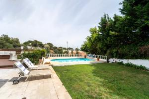 a backyard with a swimming pool and a lawn at Villa Shaz Cascais in Cascais