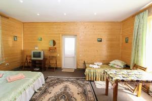 a room with two beds and a television in it at Cottage "Gribochok" in Yaremche