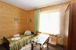 a room with a bed and a table and a window at Cottage "Gribochok" in Yaremche