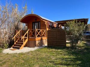 a small cabin with a wooden door and a porch at La Roulotte du Mas in Saintes-Maries-de-la-Mer