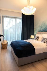 um quarto com uma cama grande e uma janela grande em Nadmorski Loft Rezydencja Niechorze 116 plaża ogród em Niechorze