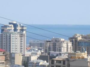uma vista para uma cidade com edifícios e o oceano em Viva 3 room apartment with jacuzzi two kilometers from the center em Baku