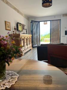 a living room with a wooden table and a couch at Rahoni Park & Suites in Dhërmi