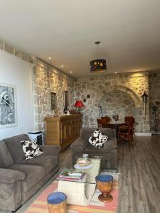 a living room with two couches and a stone wall at Rahoni Park & Suites in Dhërmi