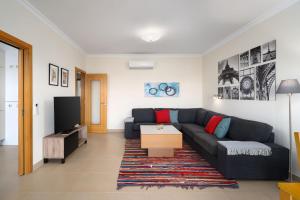 sala de estar con sofá y TV en Cozy modern apartment 111 by Destination Algarve, en Lagos