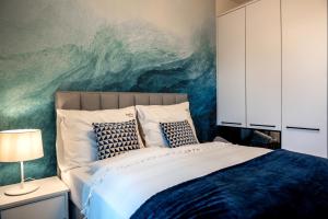 1 dormitorio con 1 cama grande y una pintura en la pared en Nadmorski Loft Rezydencja Niechorze 116 plaża ogród, en Niechorze