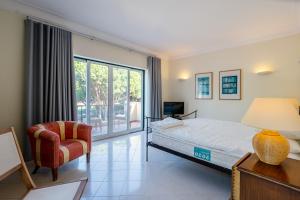 1 dormitorio con 1 cama, 1 silla y 1 ventana en Casa Atlantico en Quinta do Lago