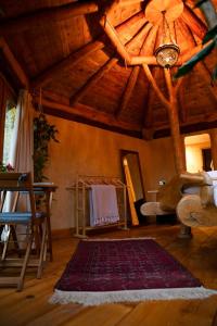 a living room with a wooden ceiling and a rug at Little Hollows Glamping in Little Malvern