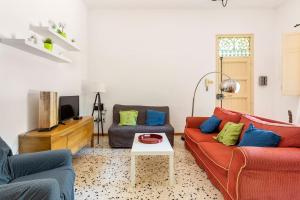 un soggiorno con 2 divani e una TV di mondello sea view beach apartment a Palermo