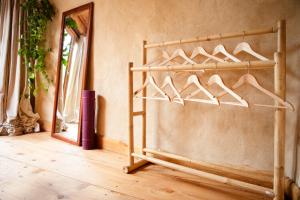 a wooden rack of hangers in a room with a mirror at Little Hollows Glamping in Little Malvern