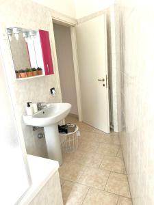 a white bathroom with a sink and a mirror at Ampio e Confortavole Appartamento a Voghera in Voghera