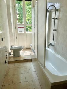 ein Badezimmer mit einer Badewanne, einem WC und einem Waschbecken in der Unterkunft Ampio e Confortavole Appartamento a Voghera in Voghera