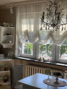 una sala da pranzo con tavolo e 2 finestre di Dom Rodzinny Rever Grand a Lubaczów