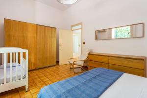 a bedroom with a bed and a desk and a chair at mondello sea view beach apartment in Palermo