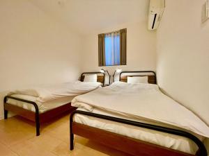 two twin beds in a room with a window at SALON渋谷4B in Tokyo