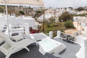 a balcony with white chairs and a hot tub at Captain's house suites in Vóthon