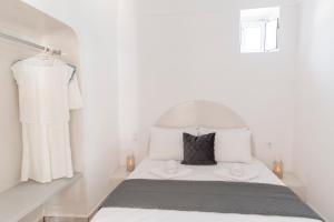 una piccola camera bianca con un letto e un comò di Captain's house suites a Vóthon