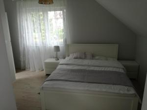 um quarto com uma cama branca e uma janela em Spanko em Sztutowo