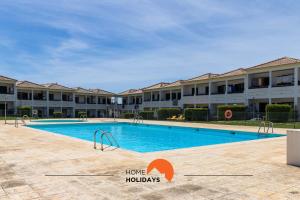 einem Pool vor einem großen Apartmenthaus in der Unterkunft #146 Fully Equiped with Pool, Garden and Balcony in Ferreiras