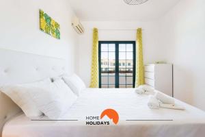a bedroom with a bed with a home holidays sign on it at #146 Summer House A6 by Home Holidays in Ferreiras +51 photos