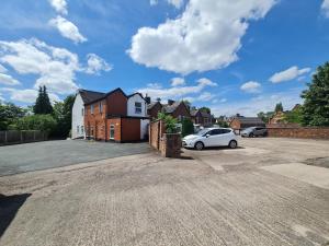 a white car parked in a parking lot with houses at ABBEY HOTEL in Stafford