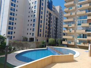 a swimming pool in front of some tall buildings at Fantástico apartamento playa in Cala de Finestrat