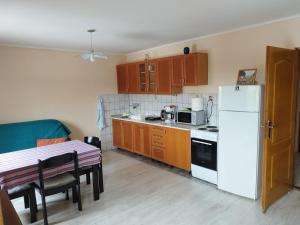 małą kuchnię ze stołem i białą lodówką w obiekcie Stancic 019 w mieście Zaječar