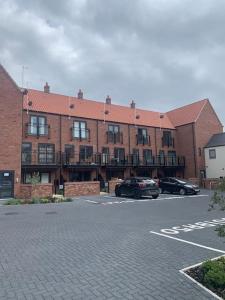 ein Parkplatz mit vor einem Gebäude geparkten Autos in der Unterkunft Fruit Market Hull in Hull