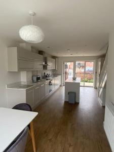 a large kitchen with white cabinets and a large window at Modern 3 Bed Town House Marina Hull in Hull