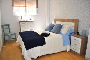 sypialnia z łóżkiem, komodą i krzesłem w obiekcie Apartamento Gran Torcal w Maladze
