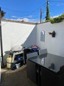 a backyard with a grill and a table next to a building at Terenure House in Terenure