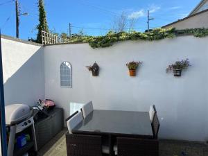a patio with a table and a white wall at Terenure House in Terenure