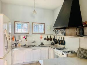 a kitchen with white cabinets and a stove top oven at Résidence Mareva in Antananarivo