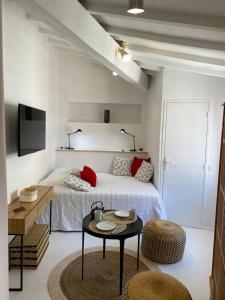 a white bedroom with a bed and a table at La Conquette 2 in Saint-Tropez