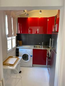 a kitchen with red cabinets and a washing machine at La Conquette 2 in Saint-Tropez